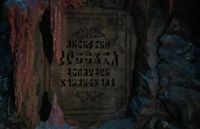 Eine Tafel in Merlin's Höhle. Auf Ihr steht Here lies Myrrdin, Archmage of the Round Übersetzt: Hier liegt Myrrdin, Erzmagier der Tafelrunde.